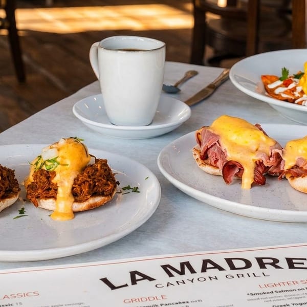 Breakfast spread at La Madre Canyon Grill with Benedicts, chilaquiles, and coffee on a table.